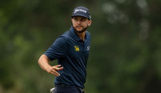 John Catlin waves to the crowd after holing a birdie putt