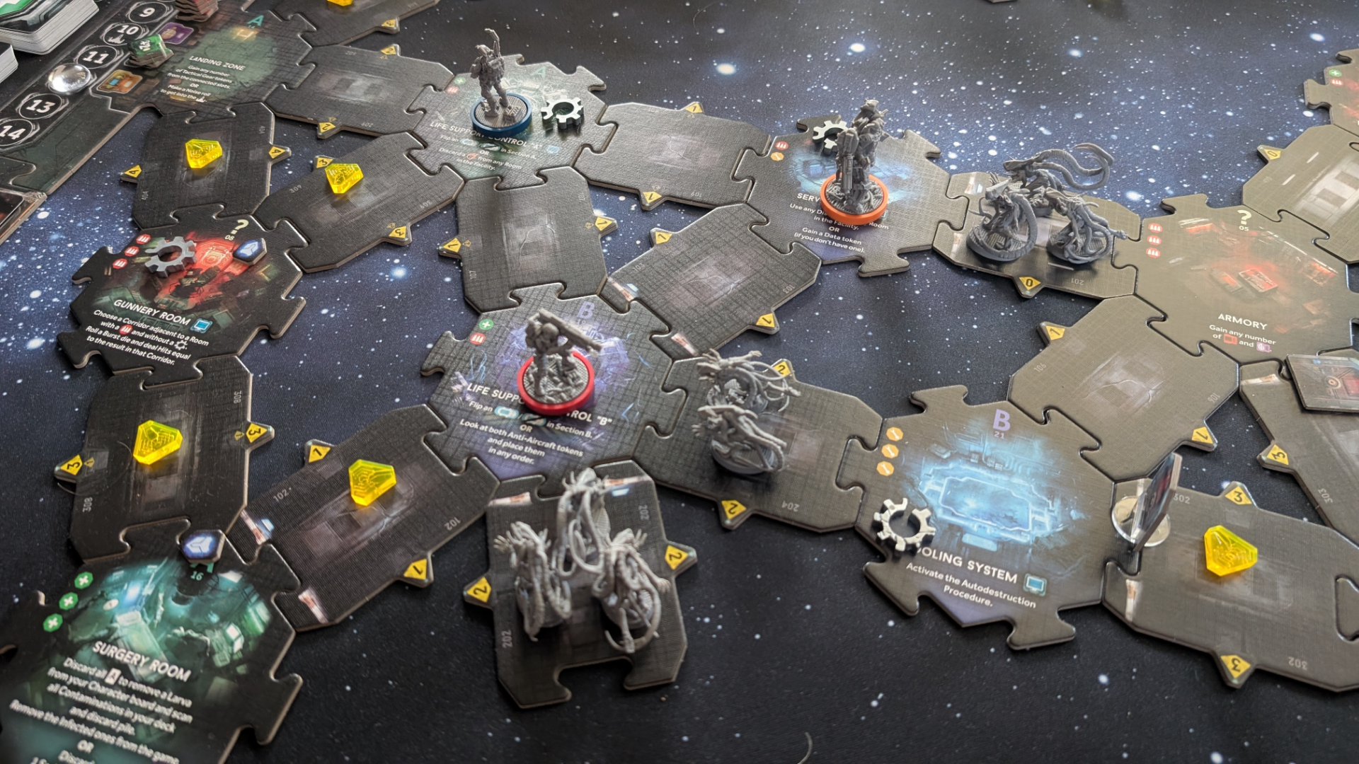Nemesis: Retaliation pieces, board tiles, and tokens on a gaming table with a starry effect