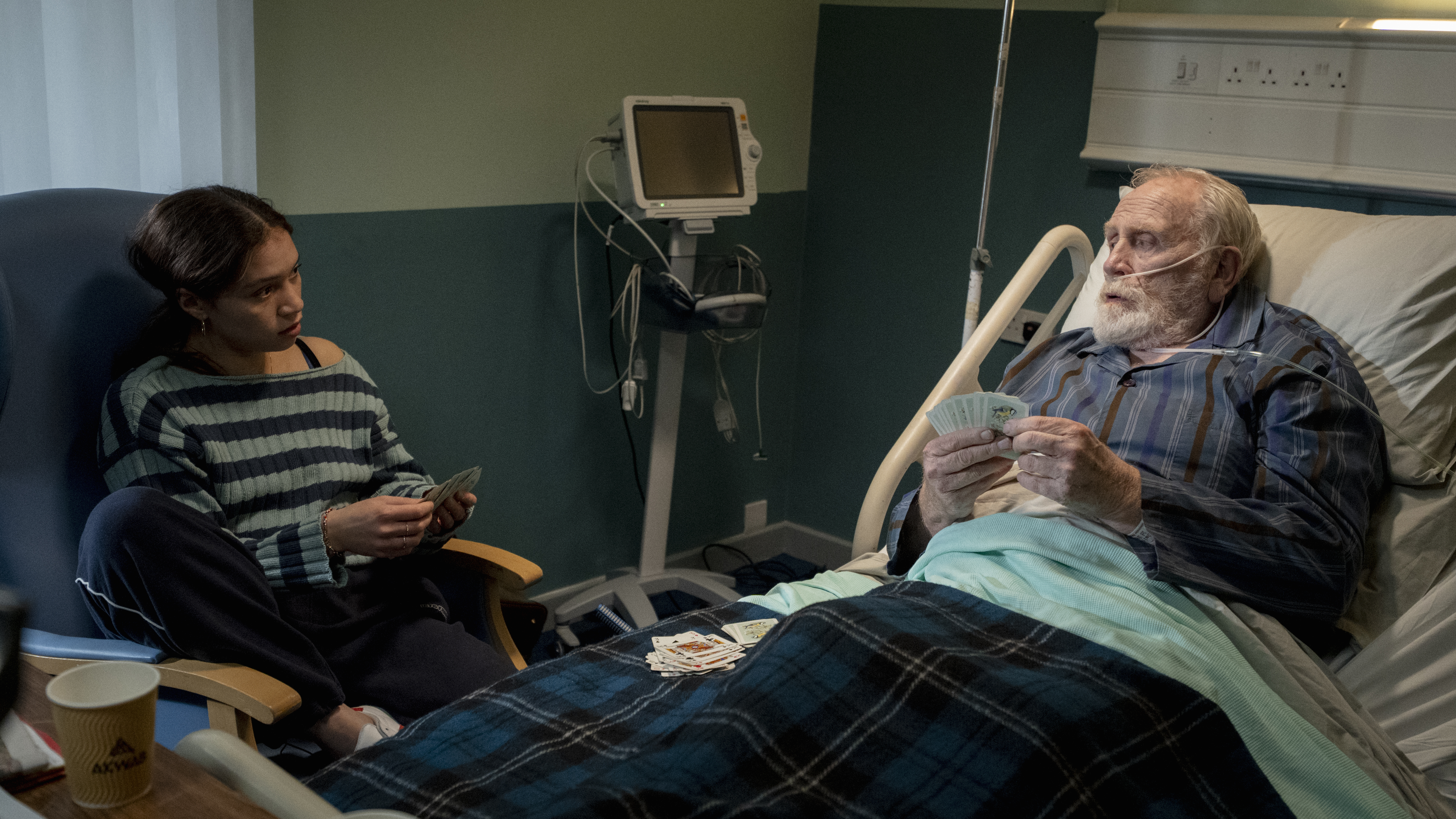 Isobel Akuwudike as Sylvie and james Cosmo as Max playing cards in a hospital room in hostage