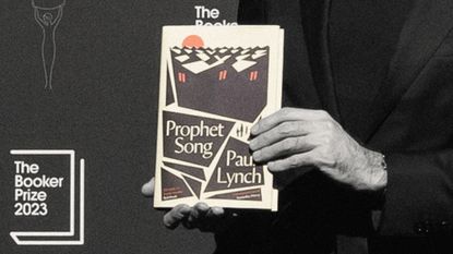 A closeup of Paul Lynch's hands holding up his book, "Prophet song", at the Booker Prize awards 2023