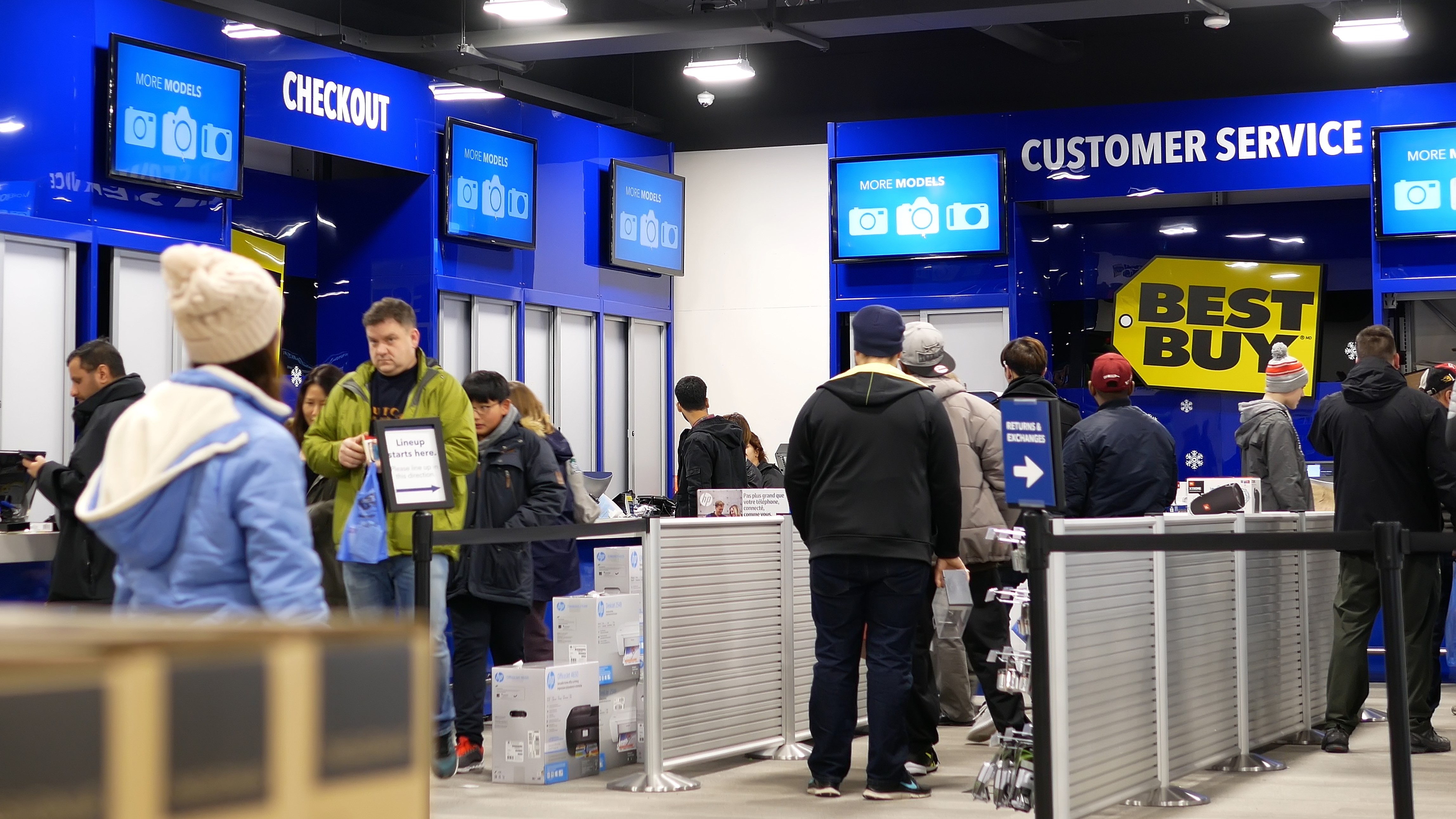 Inside of a Best Buy, an every day scene at the customer service section with people milling around