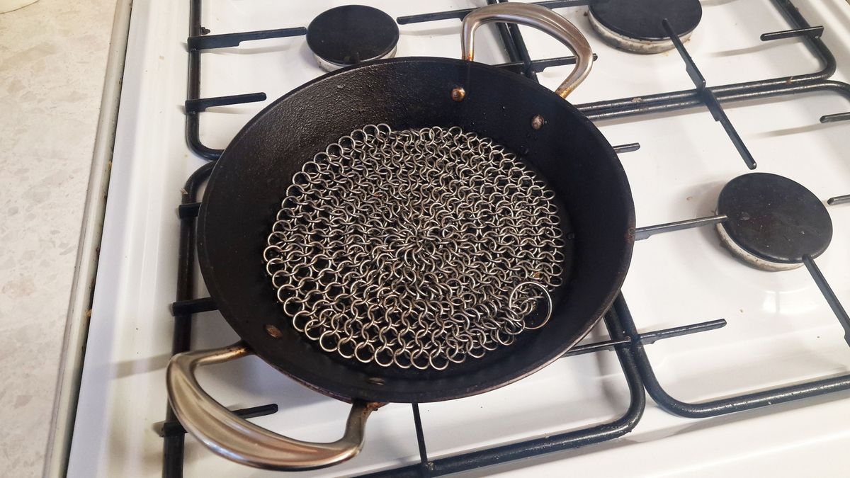 Cast iron being cleaned by a chainmail scrubber