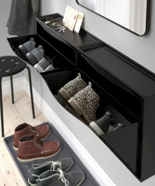 A white hallway with a black wall-mounted shoe rack