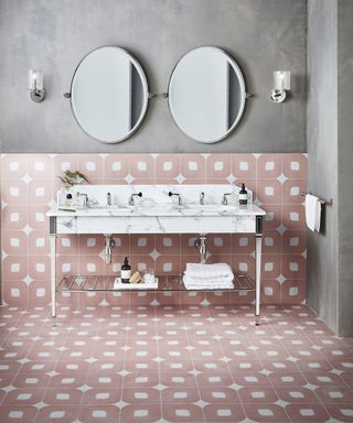 A master bathroom with a white marble double vanity and pink tiled walls and floor