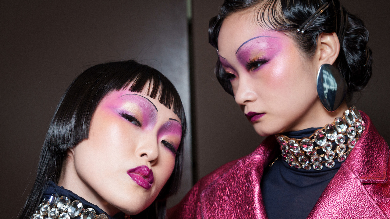 Two models wearing pink eyeshadow and posing