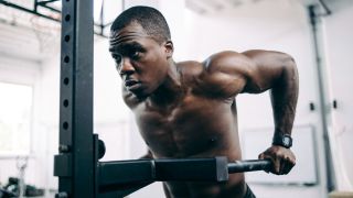 Man performs triceps dips in gym
