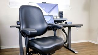 A BodyBilt Classic 2500 Series office chair in front of a black desk