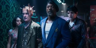 Daniela Melchior, Peter Capaldi, Idris Elba, and David Dastmalchian walk into a club in The Suicide Squad.