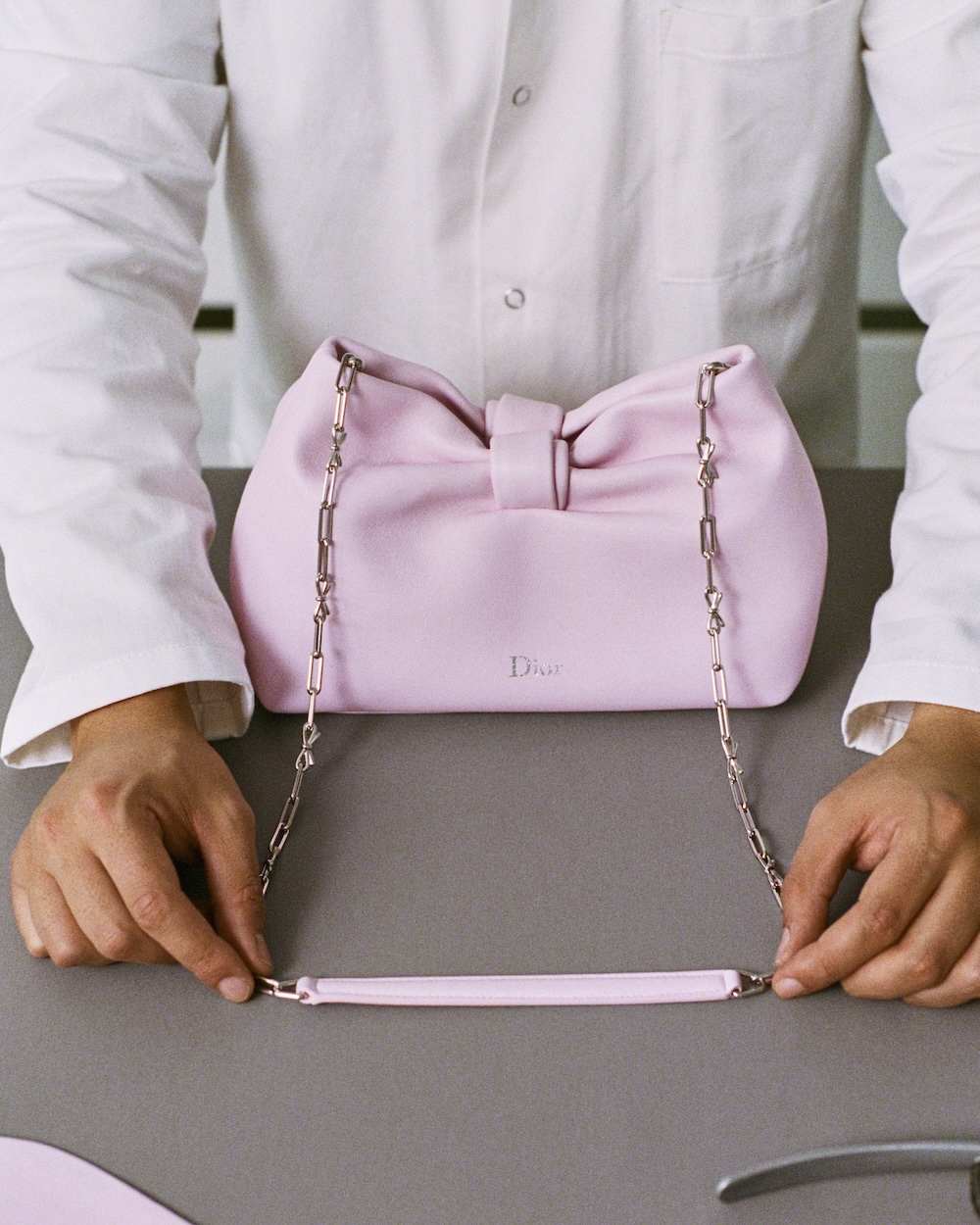 a craftsman making a Dior bow bag