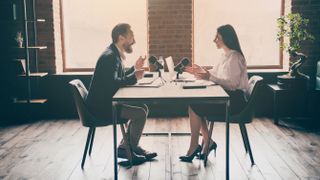 Male and female podcast hosts recording a podcast.