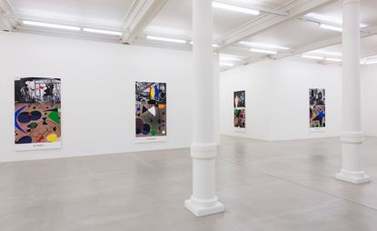 Large, white gallery space with a white pillar and four pieces of artwork