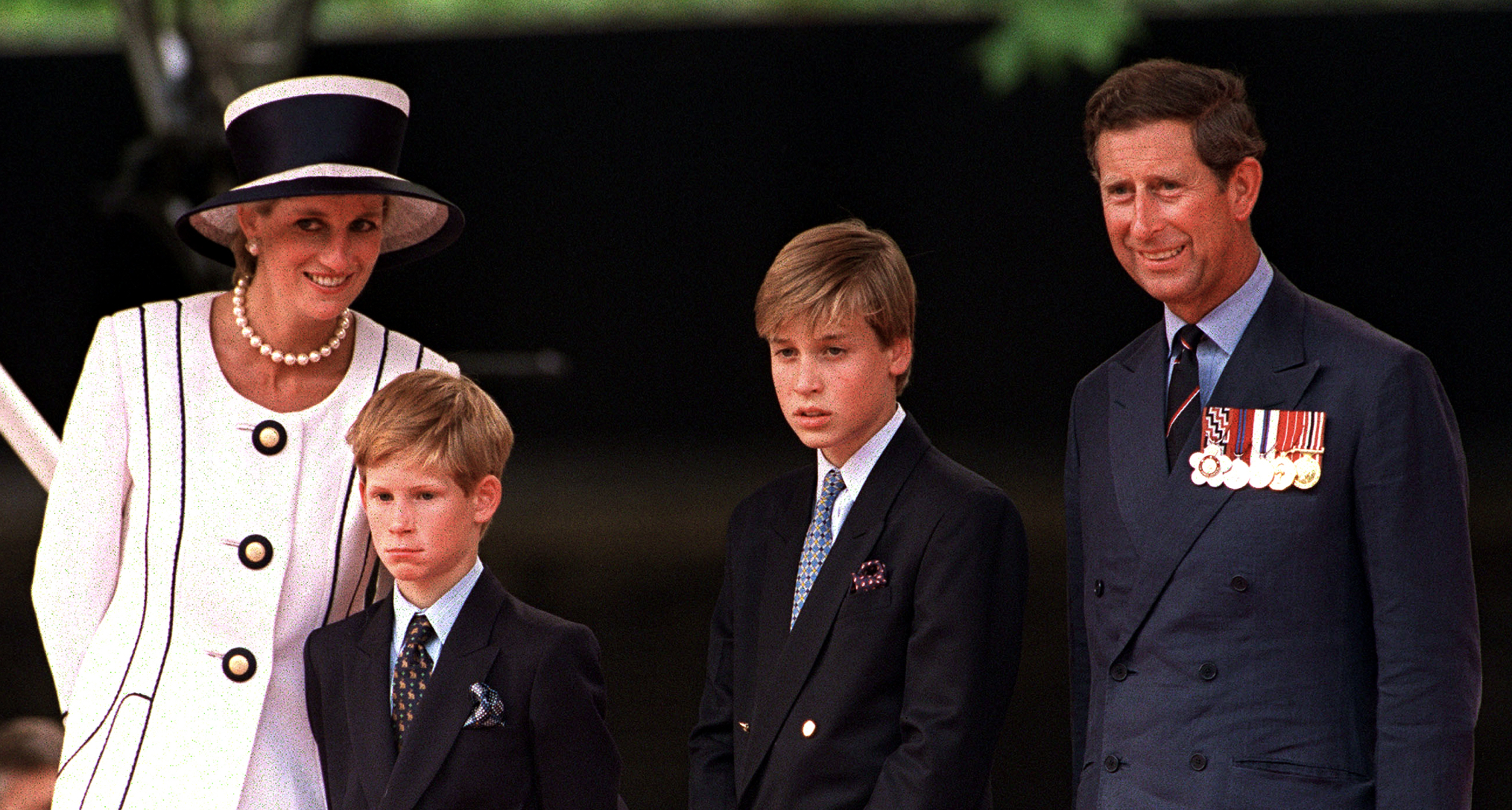 Princess Diana in a white blazer next to Prince William, Prince Harry and Prince Charles