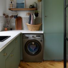 A green kitchen with a washing machine