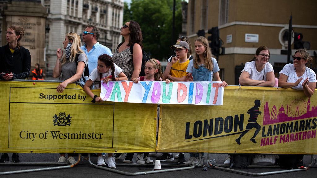 Fans display a sign reading &quot;Yay you did it&quot; cheering on runners approaching the finish line during the 2021 London Landmarks Half Marathon