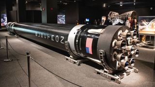a black rocket on horizontal display at an aerospace museum