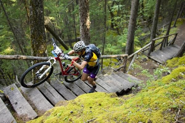Barry Wicks hikes his bike up some stairs