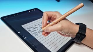 A photo of the Adonit Log stylus being used on an ipad on a desk