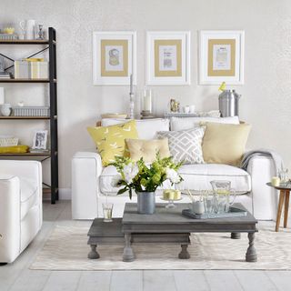 White living room with gold cushions and grey coffee table