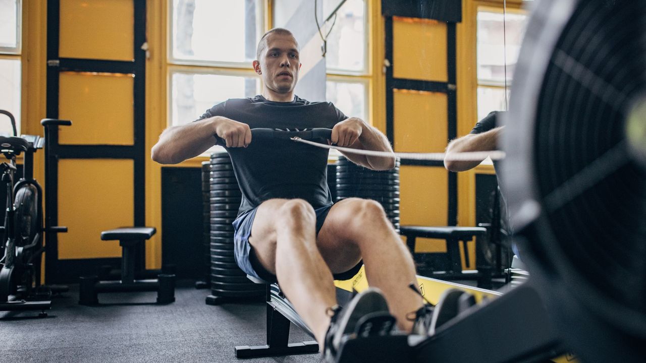 A man doing on the rowing machine at the gym