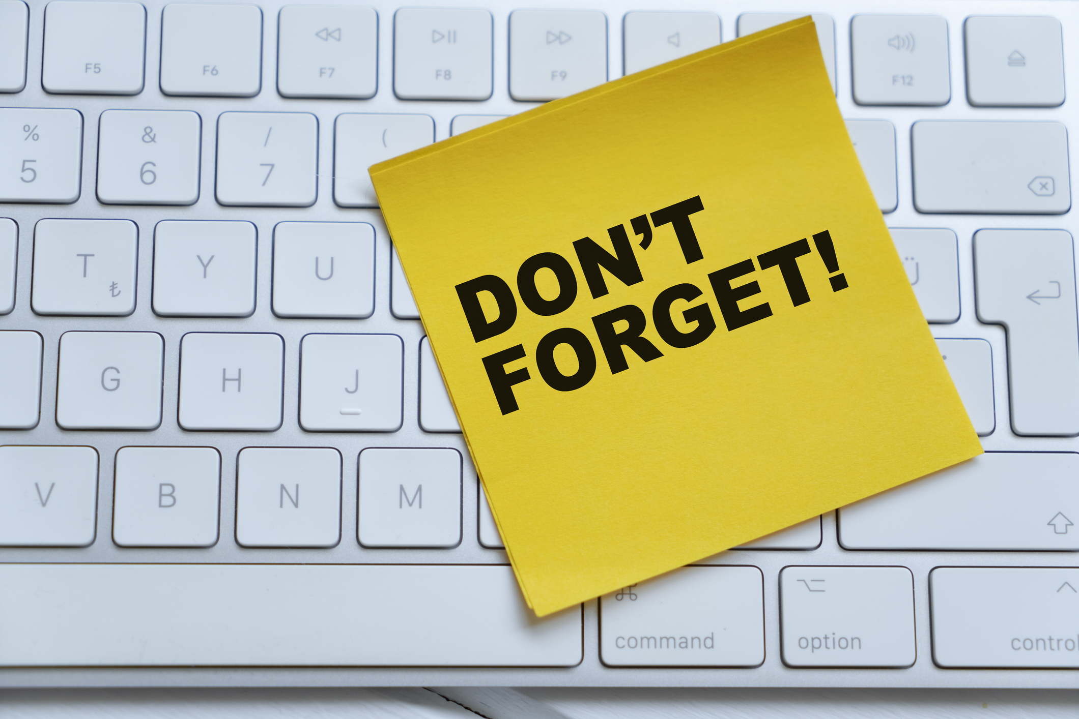 An adhesive note on a computer keyboard - Don&amp;rsquo;t forget