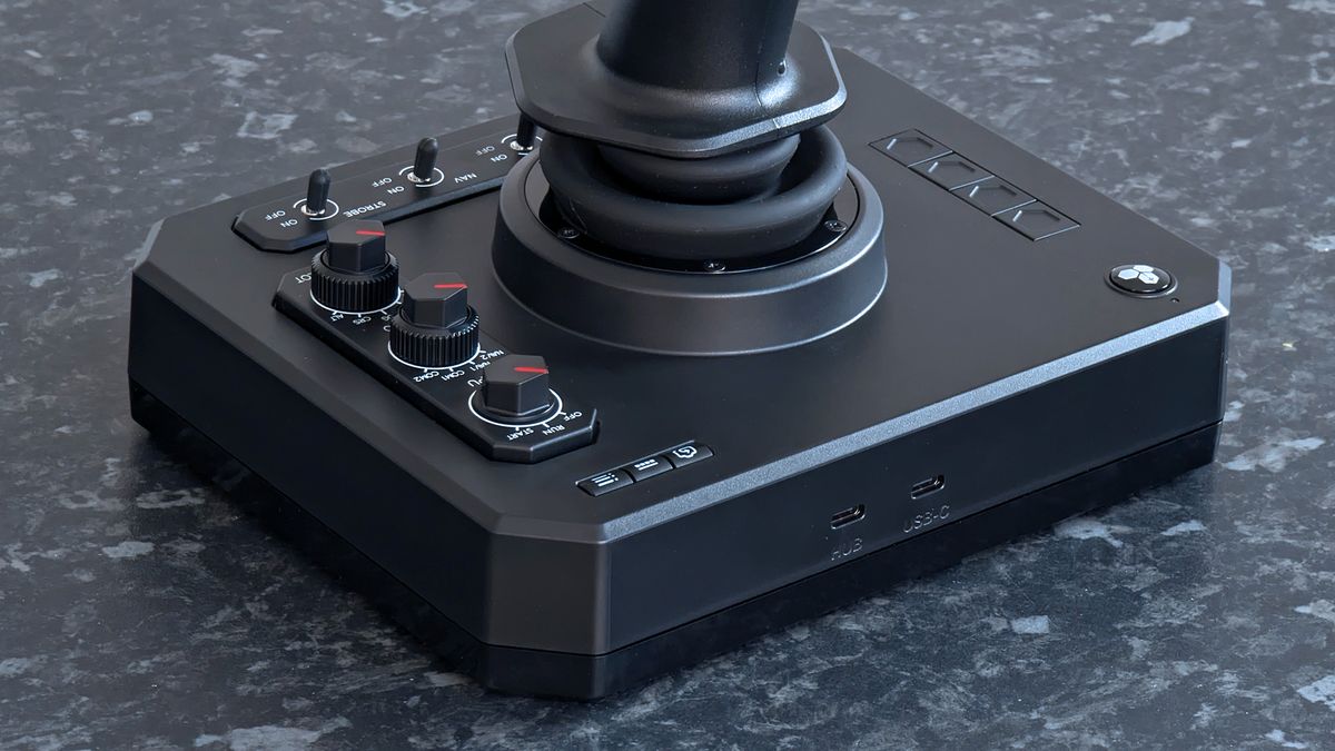 Rear USB-C ports shown alongside switches on a Honeycomb Aeronautical Foxtrot Aviation Stick, placed on a marble-patterned countertop