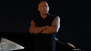 Vin Diesel staring off camera while leaning against a car at night in Fast X.