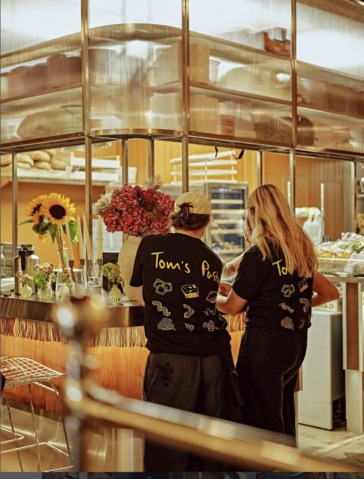 an image of two waiting staff by the restaurant's pass waiting to pick up plates for service