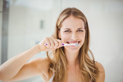 woman brushing teeth - get clued up on dental health