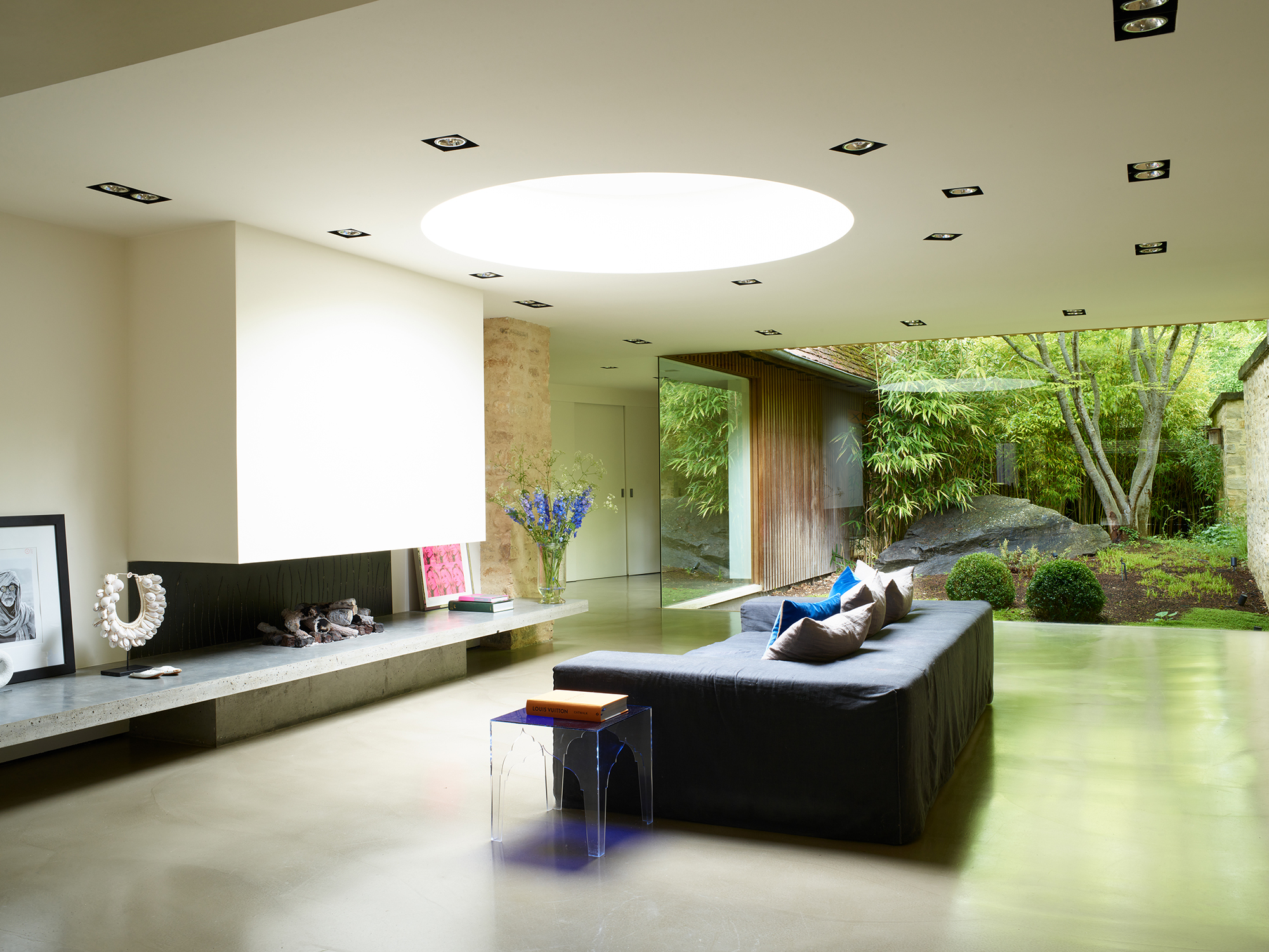 second living room with black sofa with fireplace and view to the garden