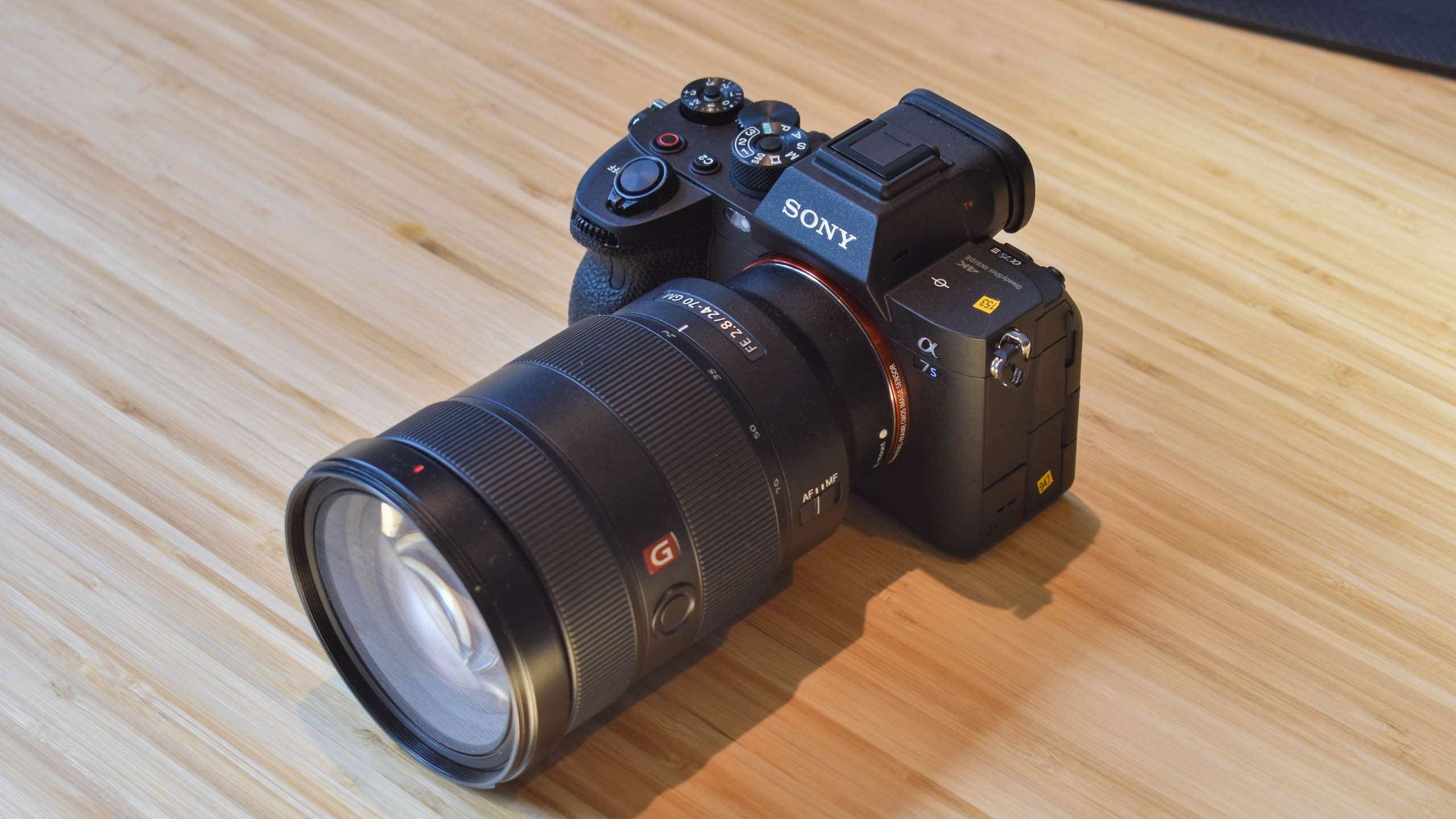 The Sony A7S III with a 24-70mm lens sitting in a wooden table