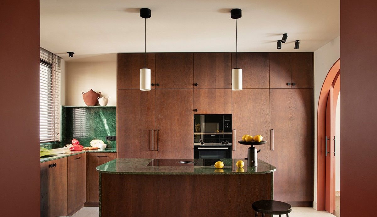 A kitchen with pendant lights above the island