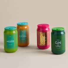 Four M&S cocktail tinny scented candles on a beige background