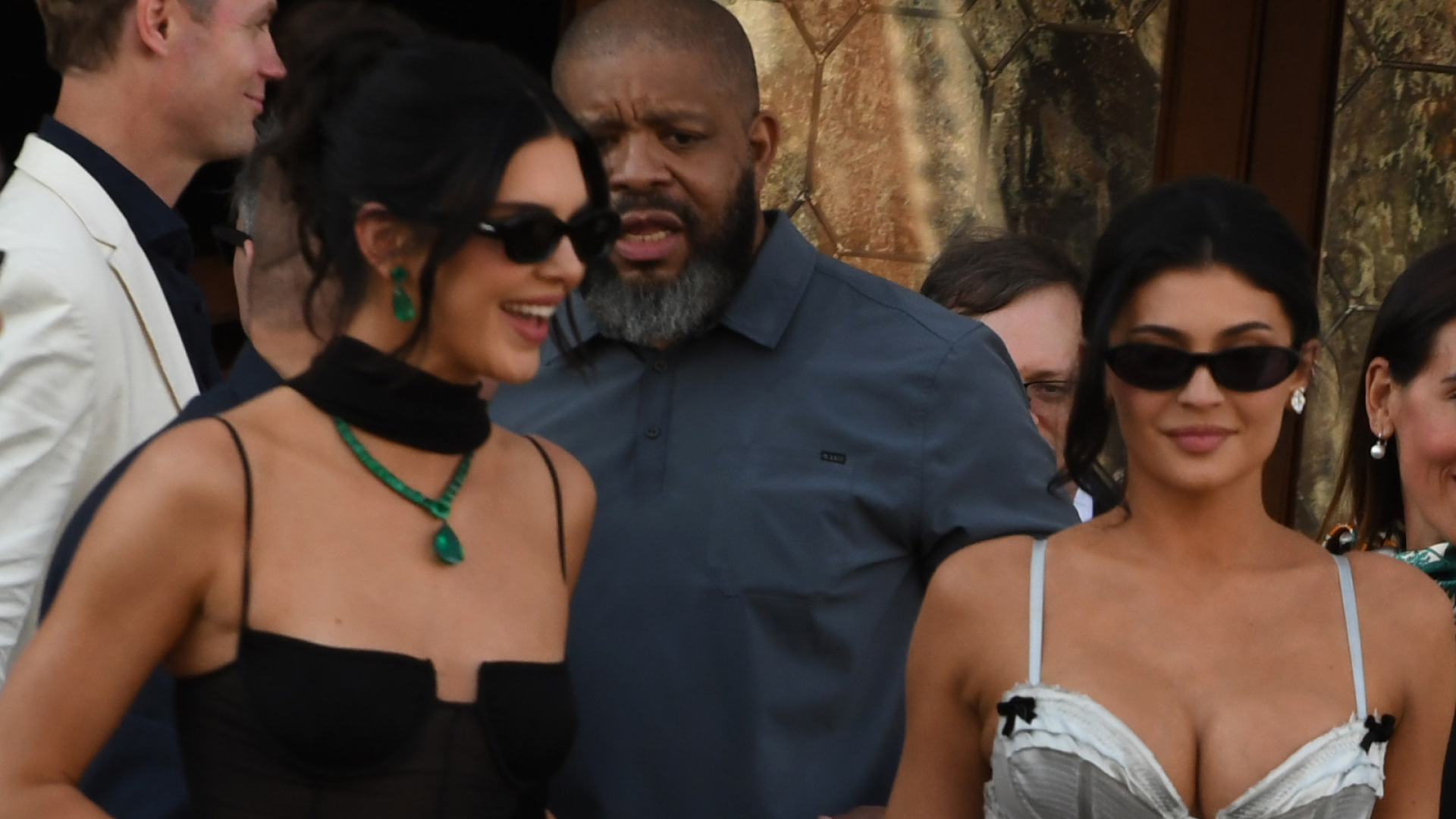 Kendall Jenner wears a sheer dress and Kylie Jenner wears a silver lace-up corset dress