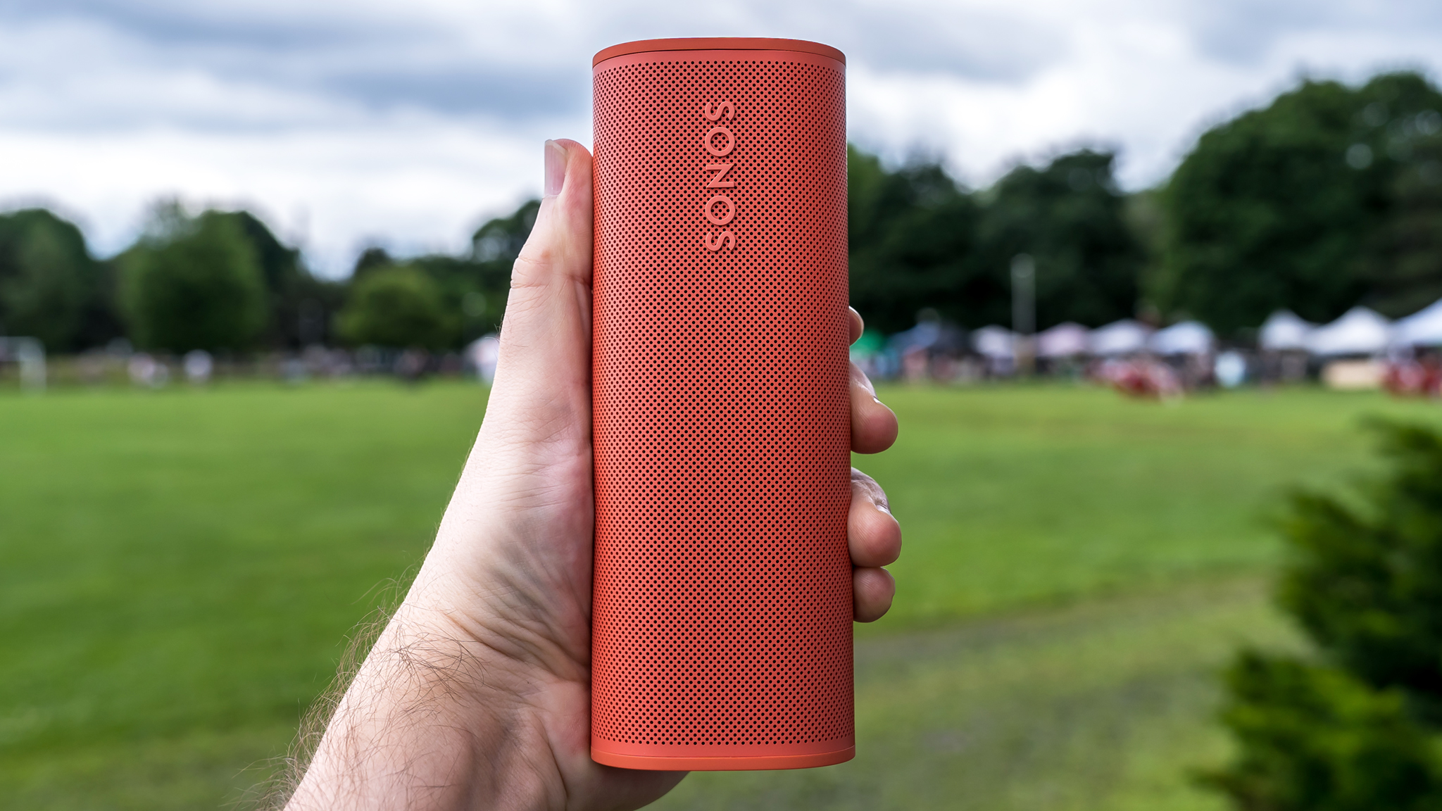 Sonos Roam 2 speaker in hand at park.