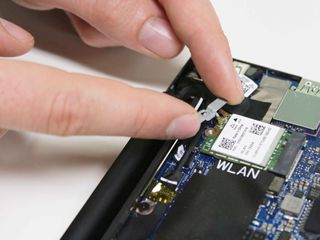 Remove the wireless card brace using your hands.