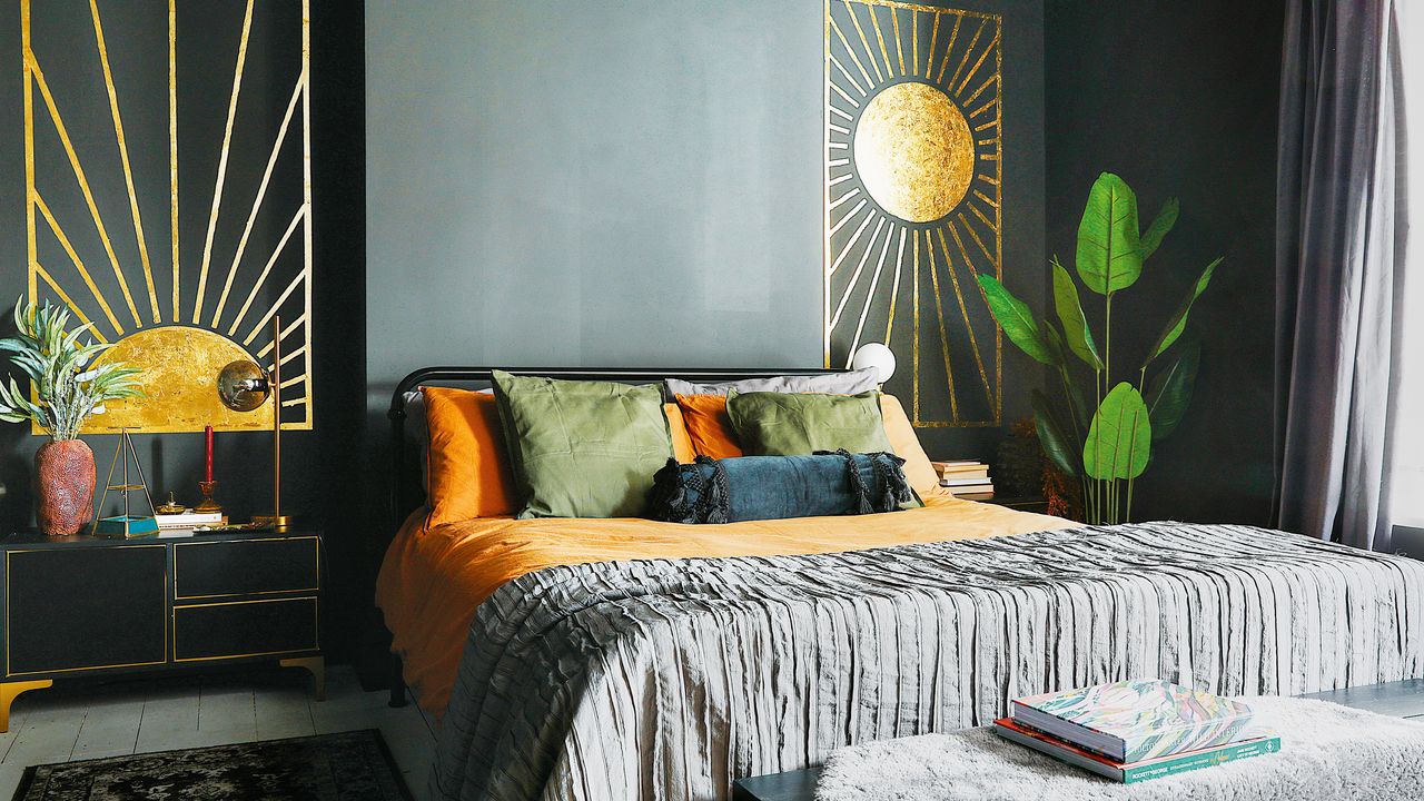 a black bedroom with metal framed bed and a gold sunshine decal on the wall