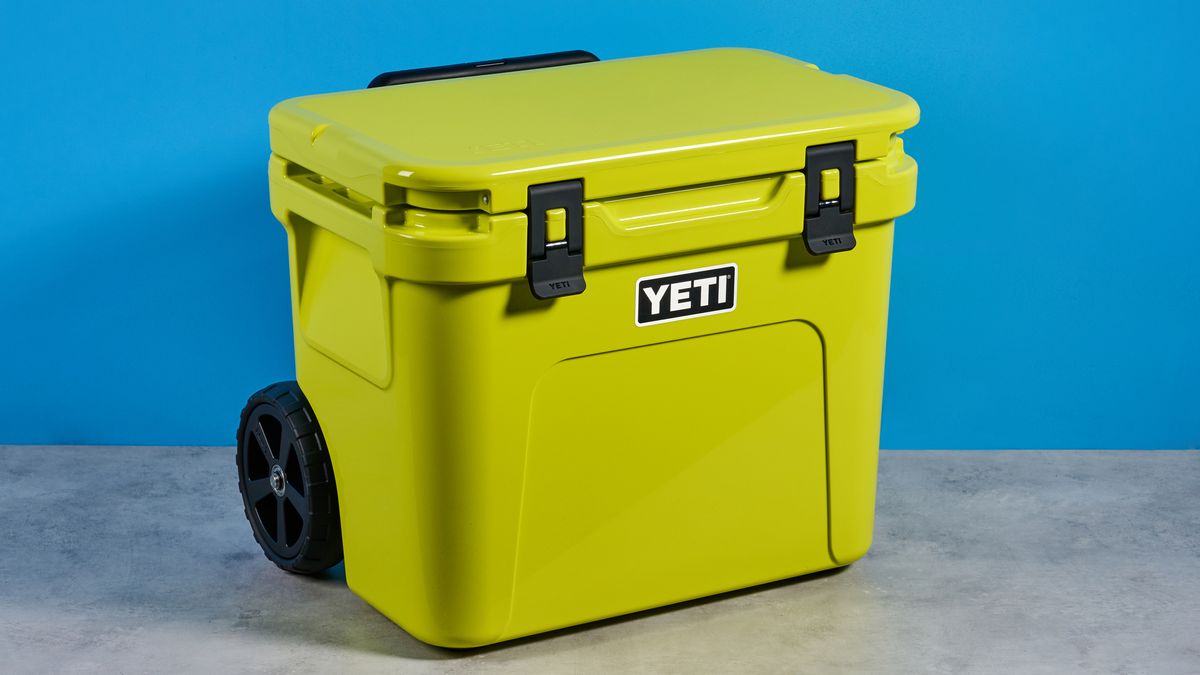 the yeti roader cooler in neon yellow with wheels, soft close hinges, a retractable handle, and 32 quart capacity