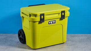 the yeti roader cooler in neon yellow with wheels, soft close hinges, a retractable handle, and 32 quart capacity