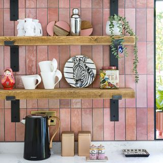 kitchen with pink tiles and wooden shelves