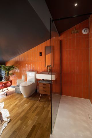 bathroom with sloping ceiling and orange wall tiles