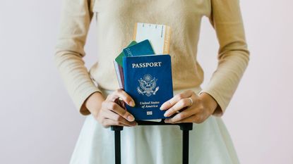 picture of woman holding a U.S. passport and an airplane boarding pass