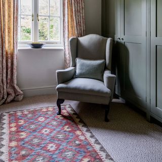 A built-in wardrobe with an armchair and carpet