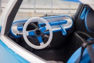 White and blue steering wheel inside blue Microlino electric microcar