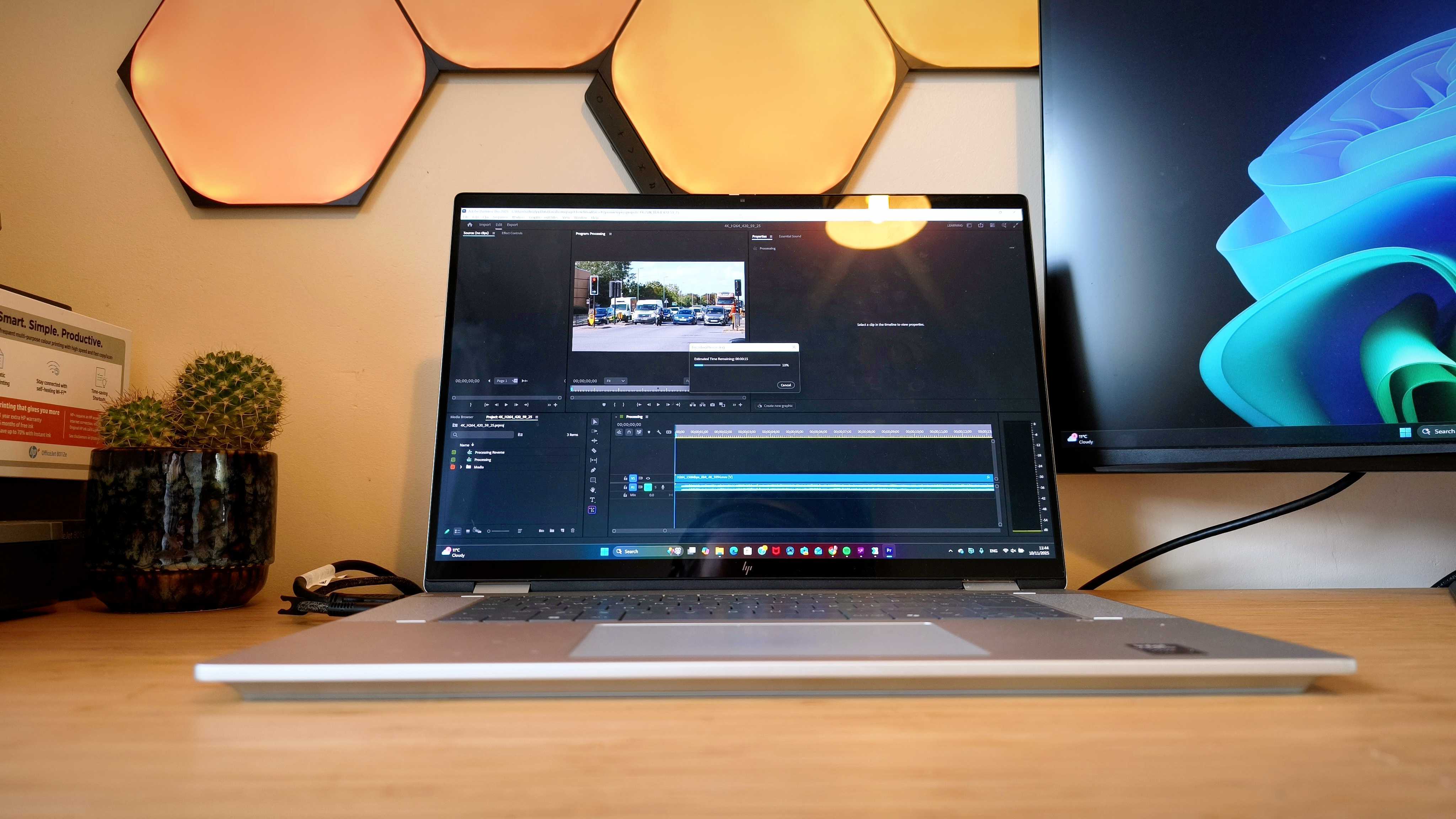 A silver HP Omnibook X Flip 16 2-in-1 laptop on a wooden desk