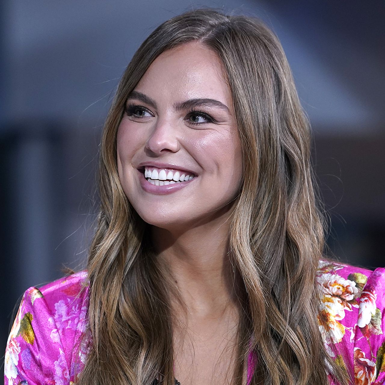 Former Bachelorette contestant Hannah Brown wearing pink against dark background