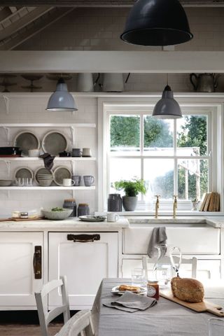 styling shelves: shelves styled in small kitchen with a white colour scheme, large window overlooking a garden