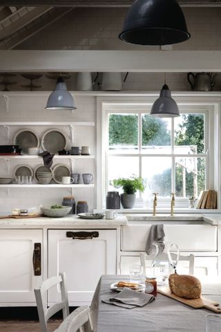 small kitchen with a white color scheme, large window overlooking a garden