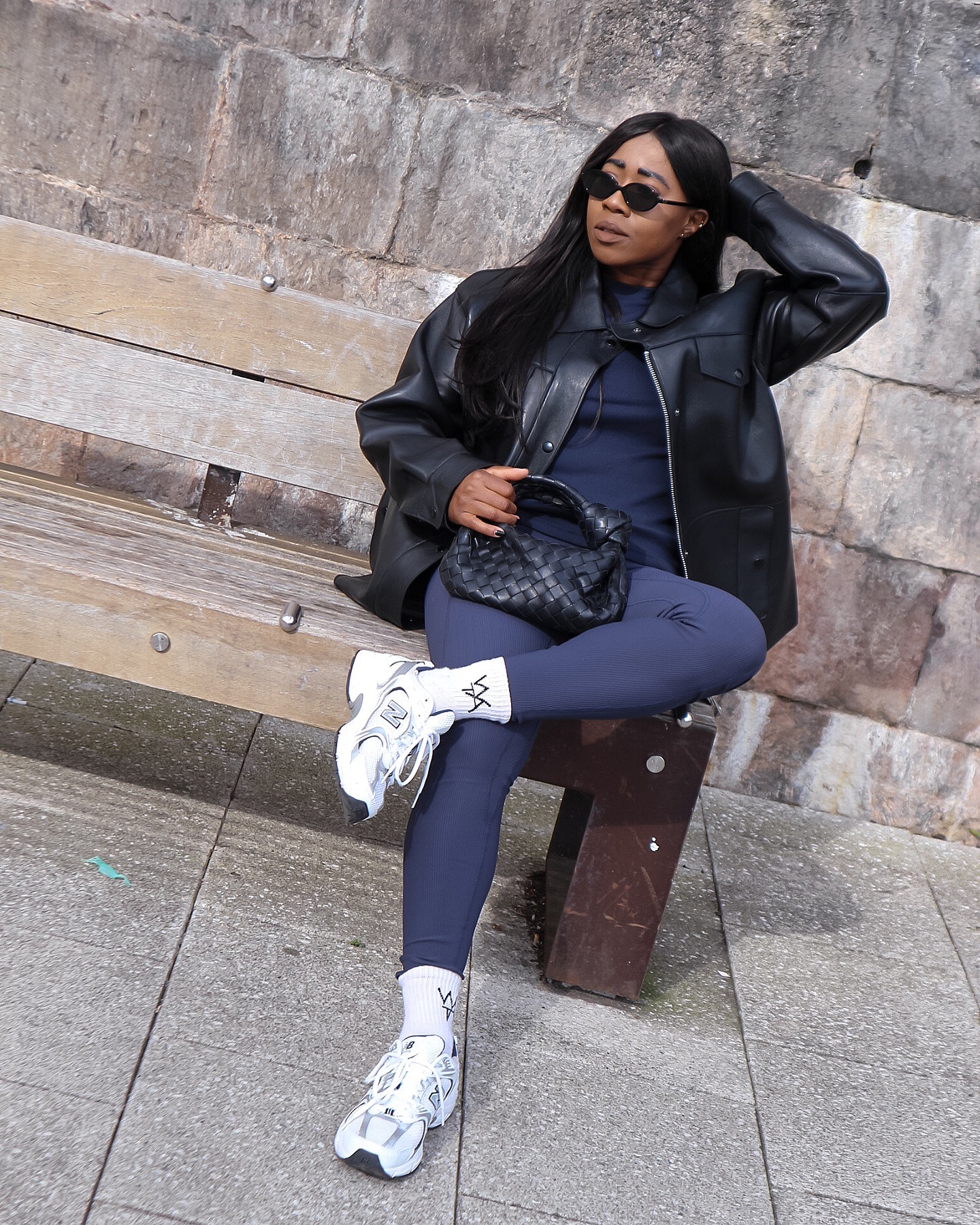 @_loissterling wears navy leggings with a navy knit and black leather jacket and white trainers.