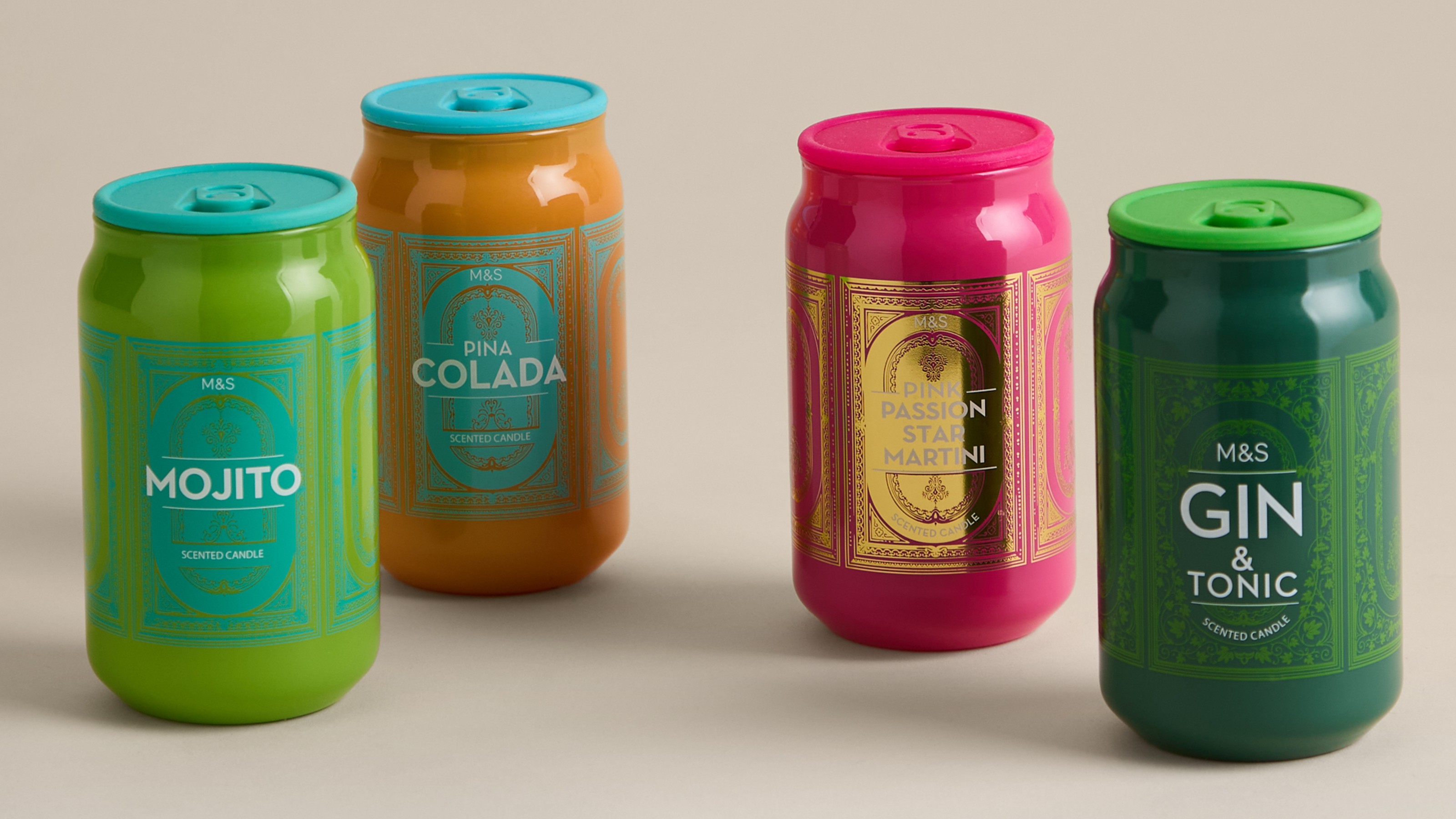 Four M&amp;S cocktail tinny scented candles on a beige background