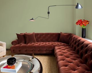 olive sprig green painted on the wall with red corner sofa